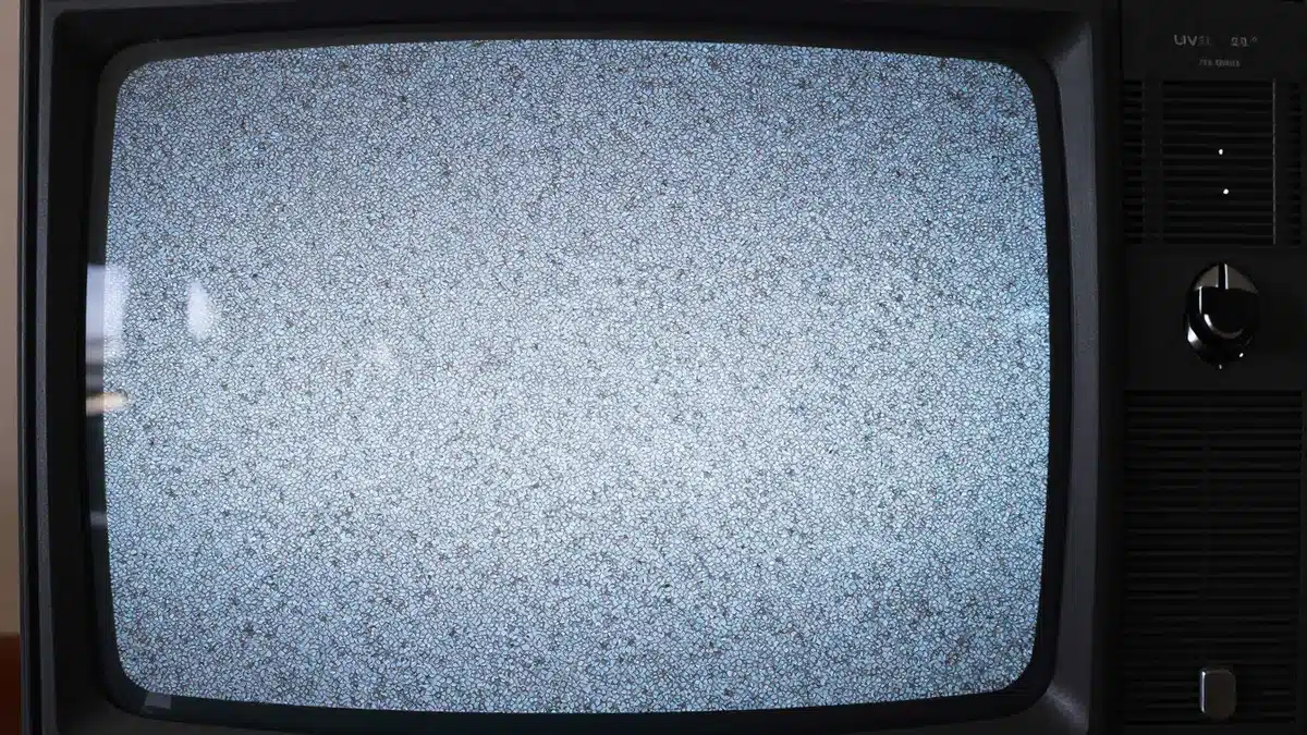 砂嵐を映す古いブラウン管テレビのノイズ画面